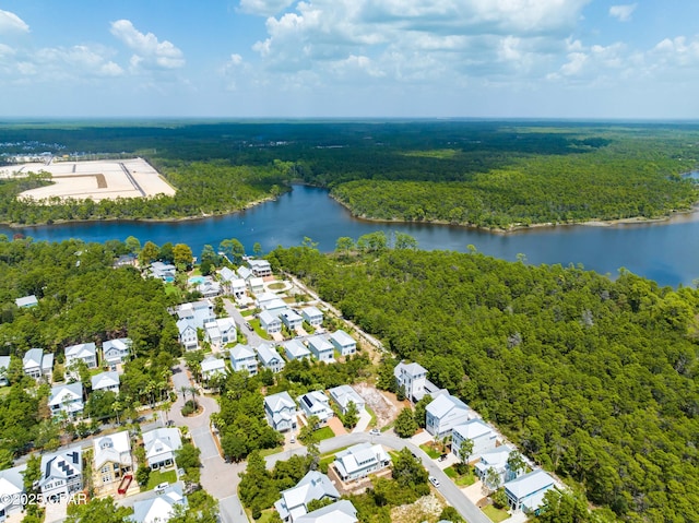 birds eye view of property featuring a water view, a residential view, and a wooded view