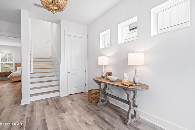 entryway featuring light wood-type flooring, visible vents, stairway, and baseboards