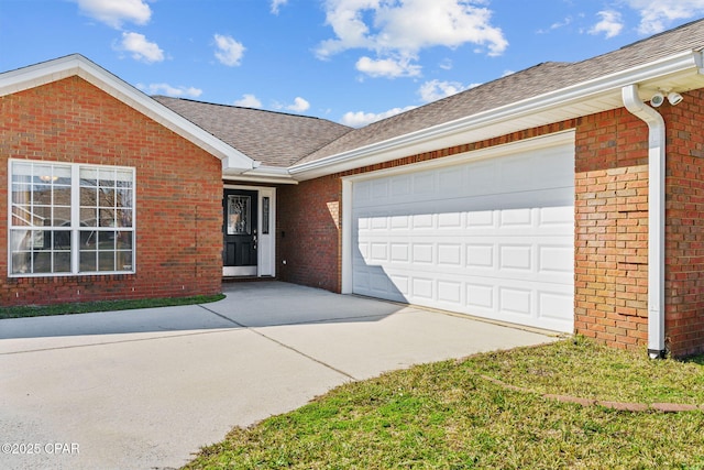 single story home with an attached garage, driveway, brick siding, and a shingled roof