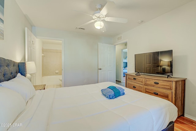 bedroom featuring baseboards, connected bathroom, and a ceiling fan