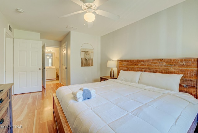 bedroom with light wood finished floors, ceiling fan, and connected bathroom