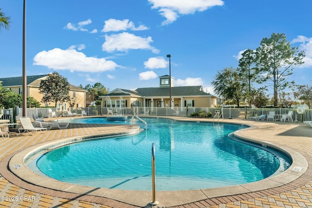 community pool featuring fence and a patio area