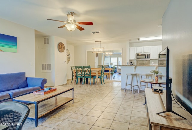 living room with a ceiling fan and light tile patterned floors