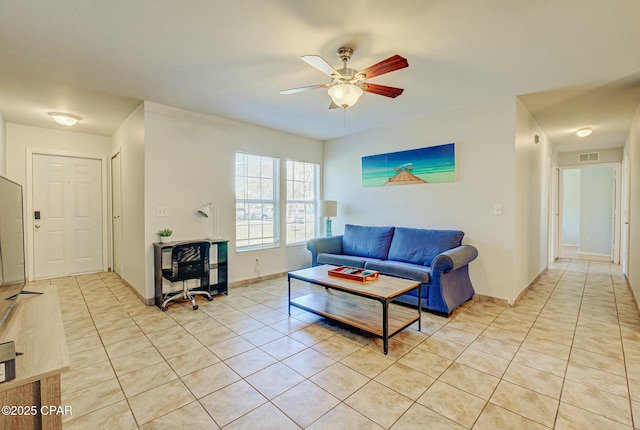 living room with light tile patterned floors, ceiling fan, and baseboards