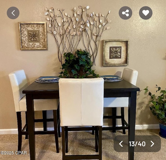 carpeted dining space with baseboards