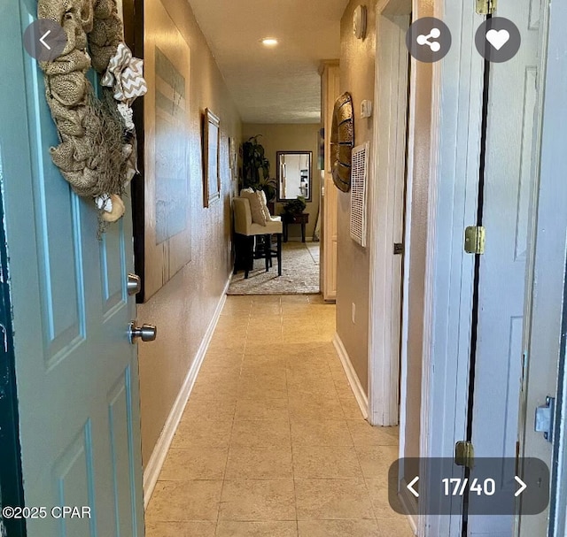 hallway with baseboards and light tile patterned floors