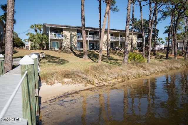 rear view of property featuring a water view and a balcony