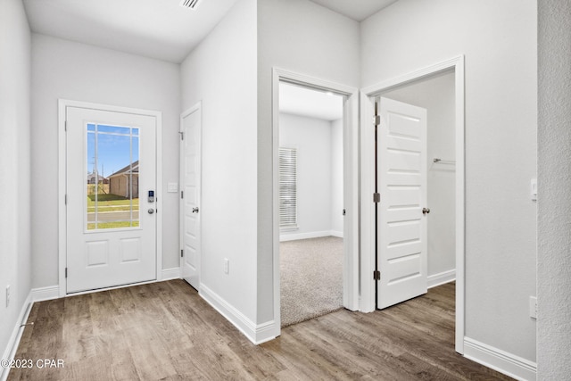 foyer entrance featuring baseboards and wood finished floors