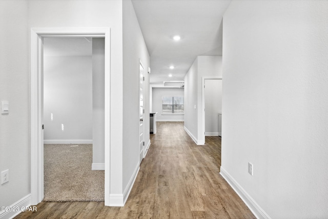 corridor with recessed lighting, baseboards, and wood finished floors