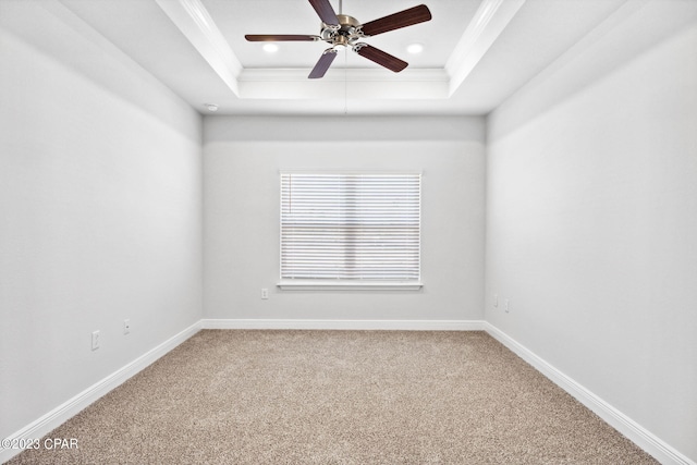 spare room with ornamental molding, a tray ceiling, recessed lighting, carpet floors, and baseboards