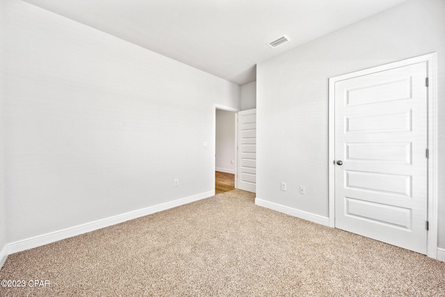 unfurnished bedroom with baseboards, visible vents, and carpet floors