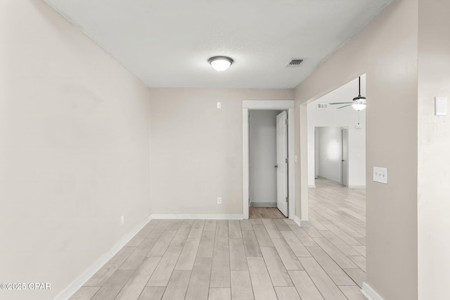 7577 Kelsey Dr, Panama City, FL 32404 - empty room featuring light wood finished floors, visible vents, baseboards, ceiling fan, and a textured ceiling