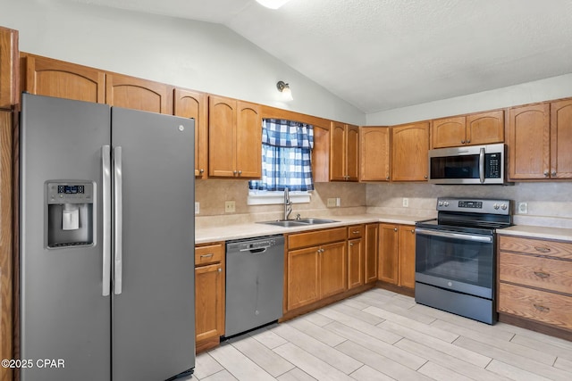 7577 Kelsey Dr, Panama City, FL 32404 - kitchen featuring lofted ceiling, a sink, stainless steel appliances, light countertops, and backsplash