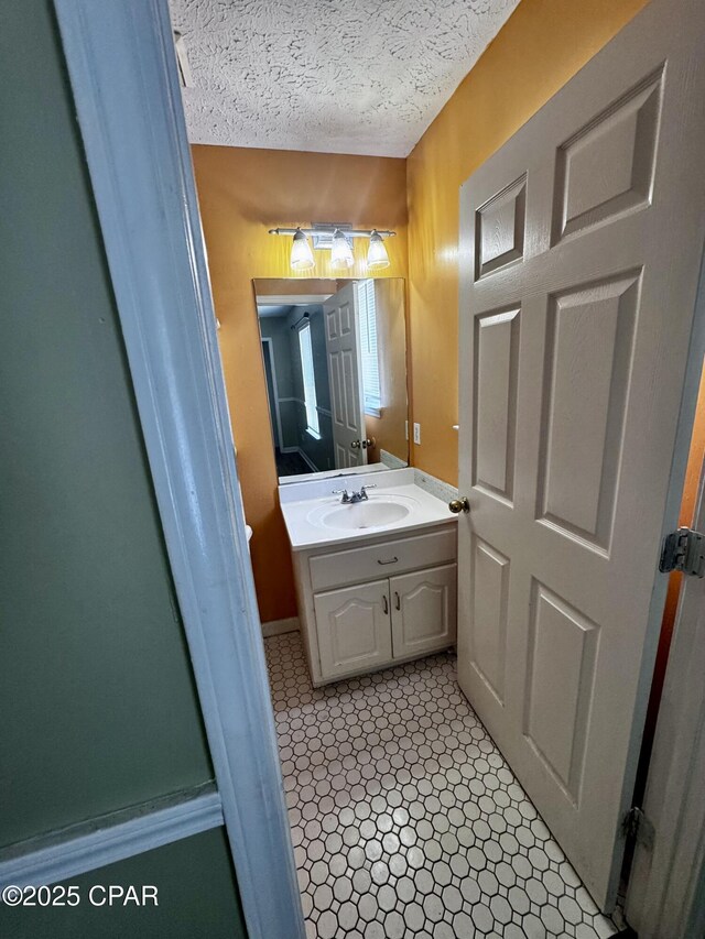 6121 Orange Plz, Panama City, FL 32408 - bathroom featuring baseboards, vanity, and a textured ceiling