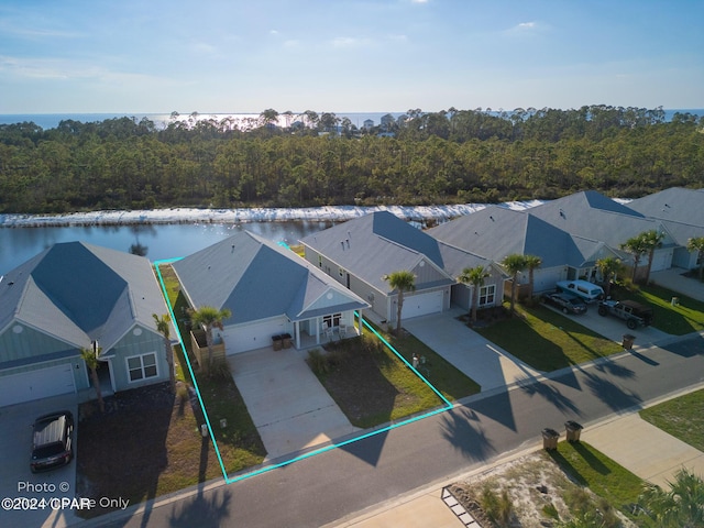 bird's eye view featuring a water view, a residential view, and a wooded view