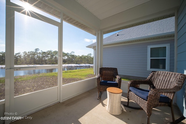 sunroom featuring a water view