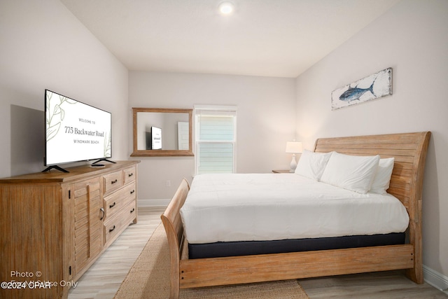 bedroom with light wood finished floors and baseboards