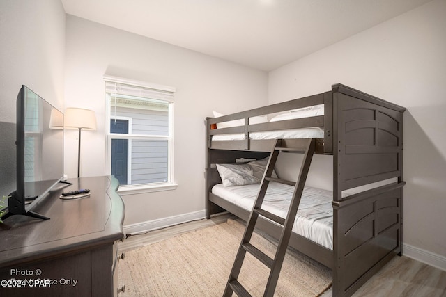 bedroom with wood finished floors and baseboards