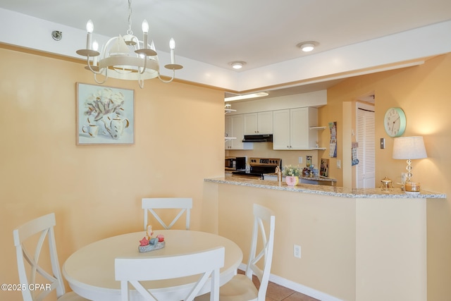 8730 Thomas Dr Unit 1201-B, Panama City Beach, FL 32408 - dining area featuring an inviting chandelier and light tile patterned floors