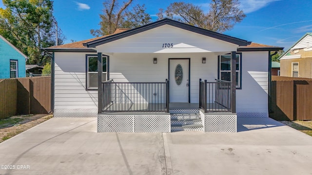 bungalow-style house featuring a porch and fence