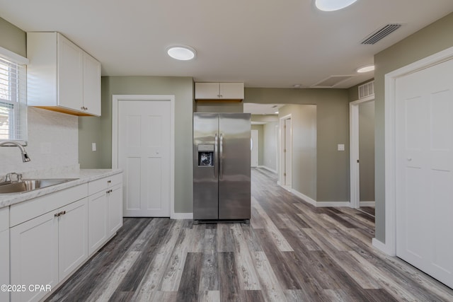 1705 Lake Ave, Panama City, FL 32401 - kitchen with stainless steel fridge, a sink, white cabinetry, and wood finished floors