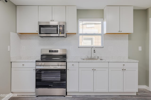 1705 Lake Ave, Panama City, FL 32401 - kitchen with stainless steel appliances, a sink, white cabinets, and tasteful backsplash