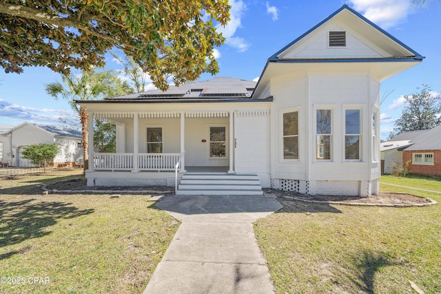 bungalow featuring metal roof, a porch, solar panels, crawl space, and a front yard