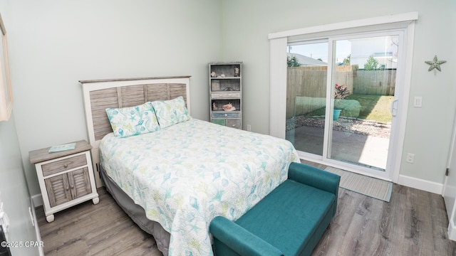 bedroom featuring access to outside, wood finished floors, and baseboards