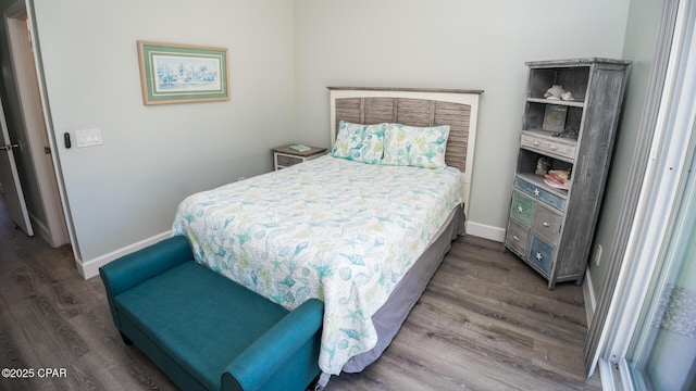 bedroom with wood finished floors and baseboards