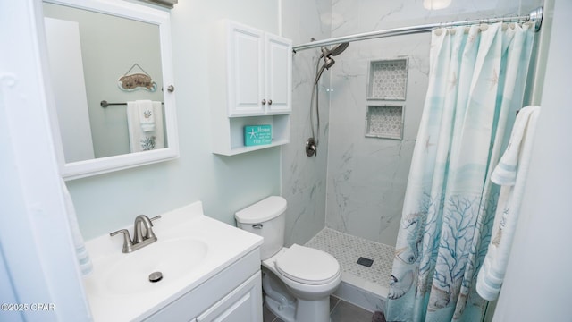 bathroom with toilet, a shower stall, and vanity