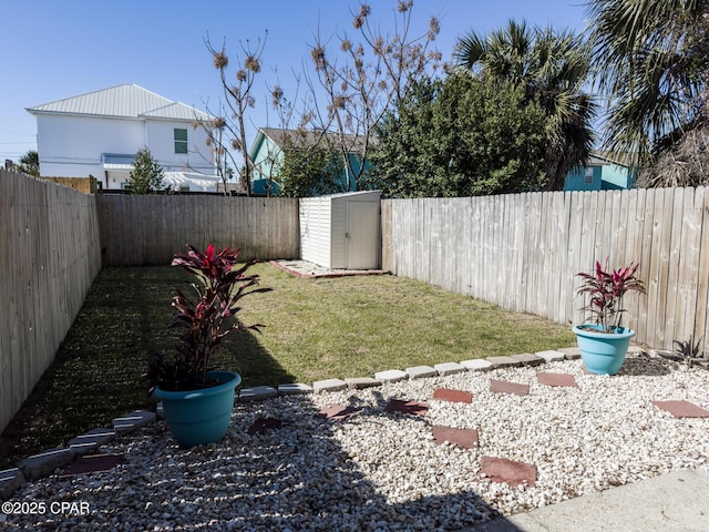 view of yard with an outbuilding, a fenced backyard, and a shed