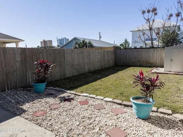 view of yard featuring a fenced backyard, an outdoor structure, and a shed