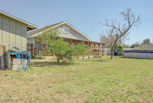 view of yard featuring a covered pool, fence, and a wooden deck