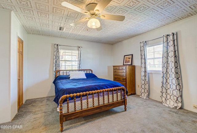 bedroom with an ornate ceiling, visible vents, ceiling fan, and carpet flooring