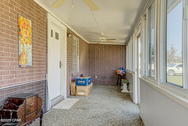 unfurnished sunroom featuring ceiling fan