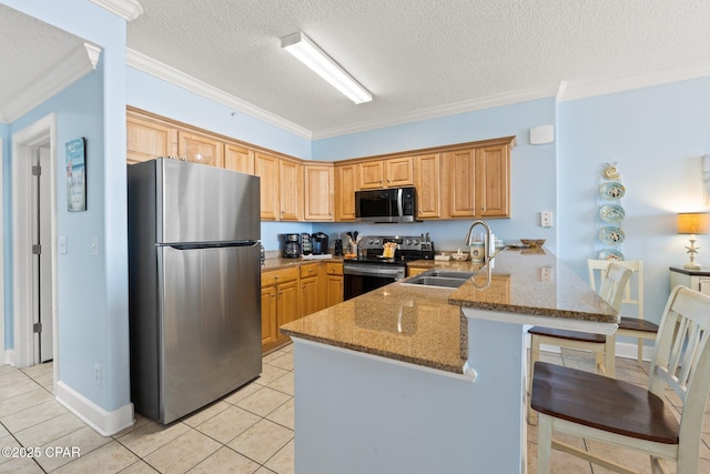 kitchen featuring a peninsula, light tile patterned flooring, ornamental molding, a sink, and appliances with stainless steel finishes