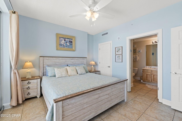 bedroom featuring light tile patterned floors, visible vents, baseboards, and connected bathroom