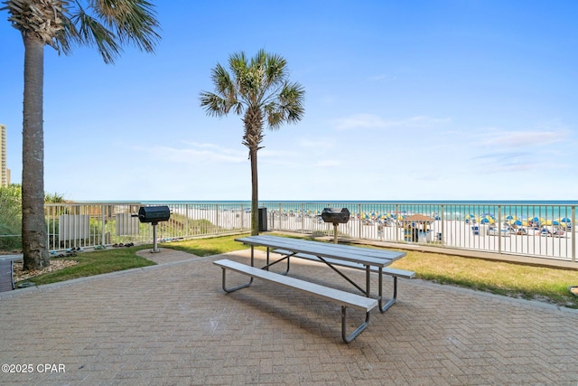 view of community featuring fence, a view of the beach, and a water view