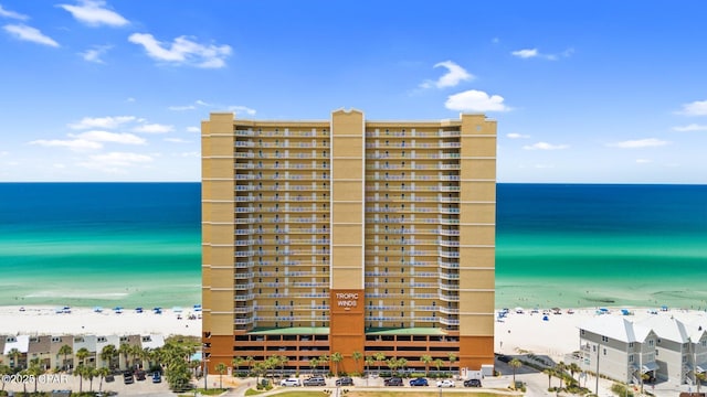 view of building exterior with a beach view and a water view