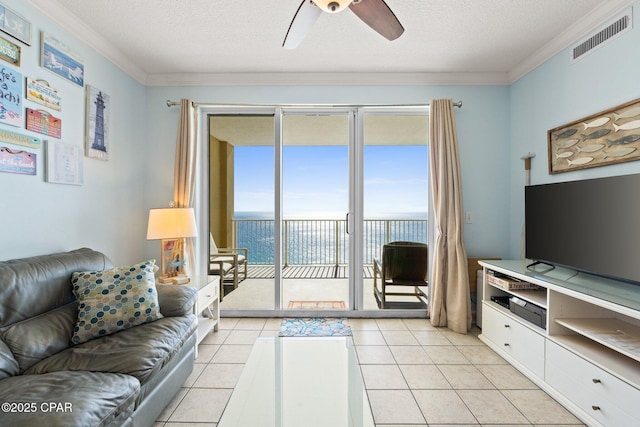 living room with visible vents, ornamental molding, a ceiling fan, a textured ceiling, and light tile patterned flooring