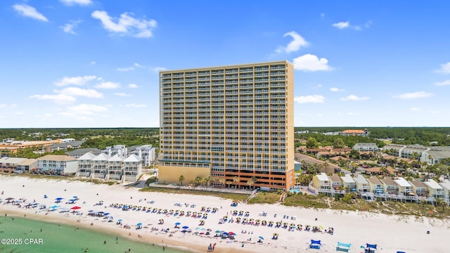 view of building exterior featuring a water view and a beach view