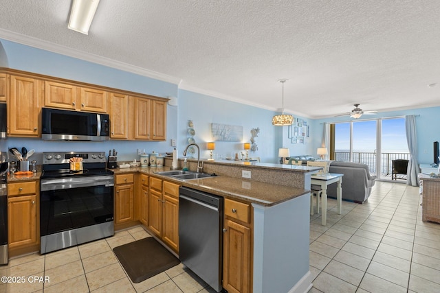 kitchen featuring a sink, open floor plan, stainless steel appliances, a peninsula, and light tile patterned floors