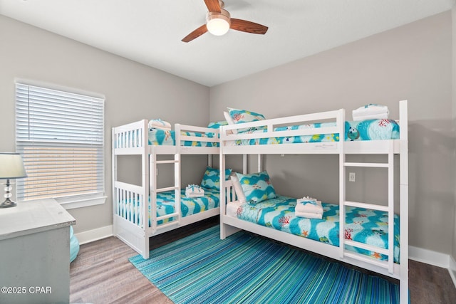 bedroom with a ceiling fan, baseboards, and wood finished floors