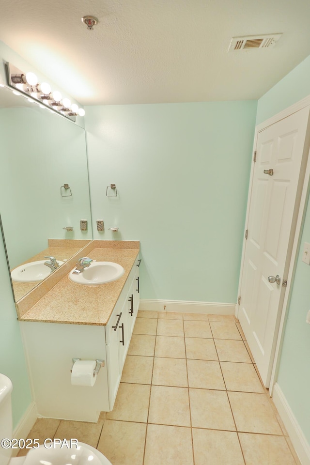 bathroom featuring tile patterned flooring, vanity, visible vents, and baseboards
