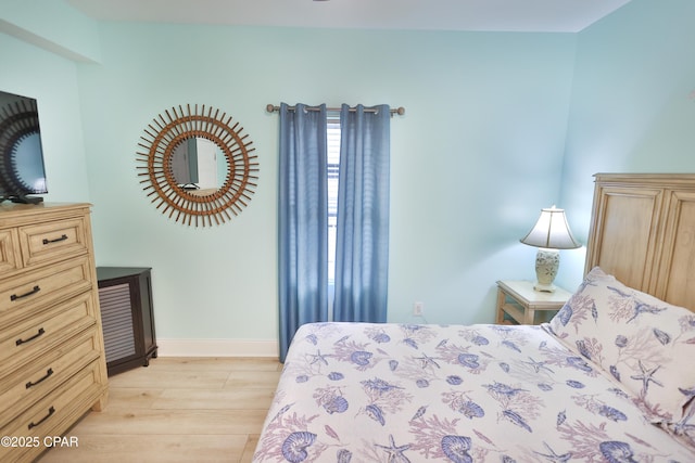 bedroom with baseboards and light wood finished floors
