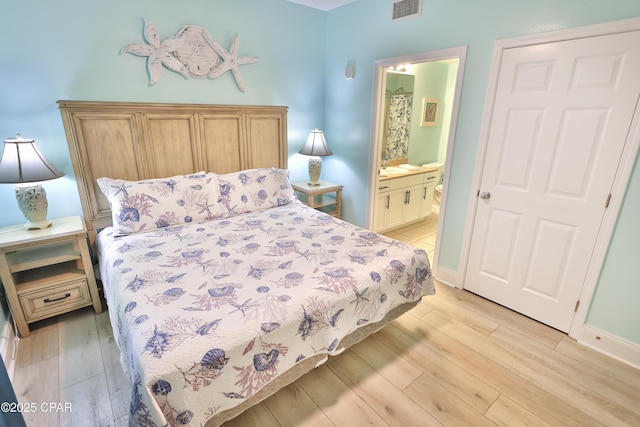 bedroom featuring light wood finished floors, visible vents, connected bathroom, and baseboards
