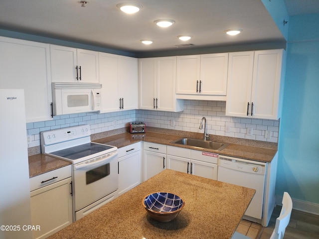 kitchen with white appliances, a sink, visible vents, white cabinets, and tasteful backsplash