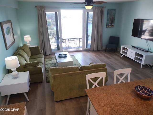 living area with dark wood-type flooring and a ceiling fan