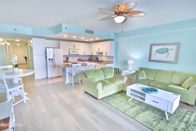 living room with visible vents, recessed lighting, light wood-style floors, and a ceiling fan