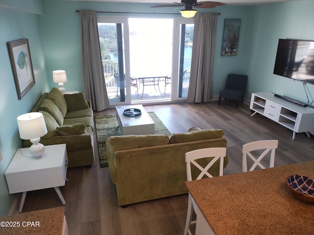 living area with ceiling fan and dark wood-style flooring